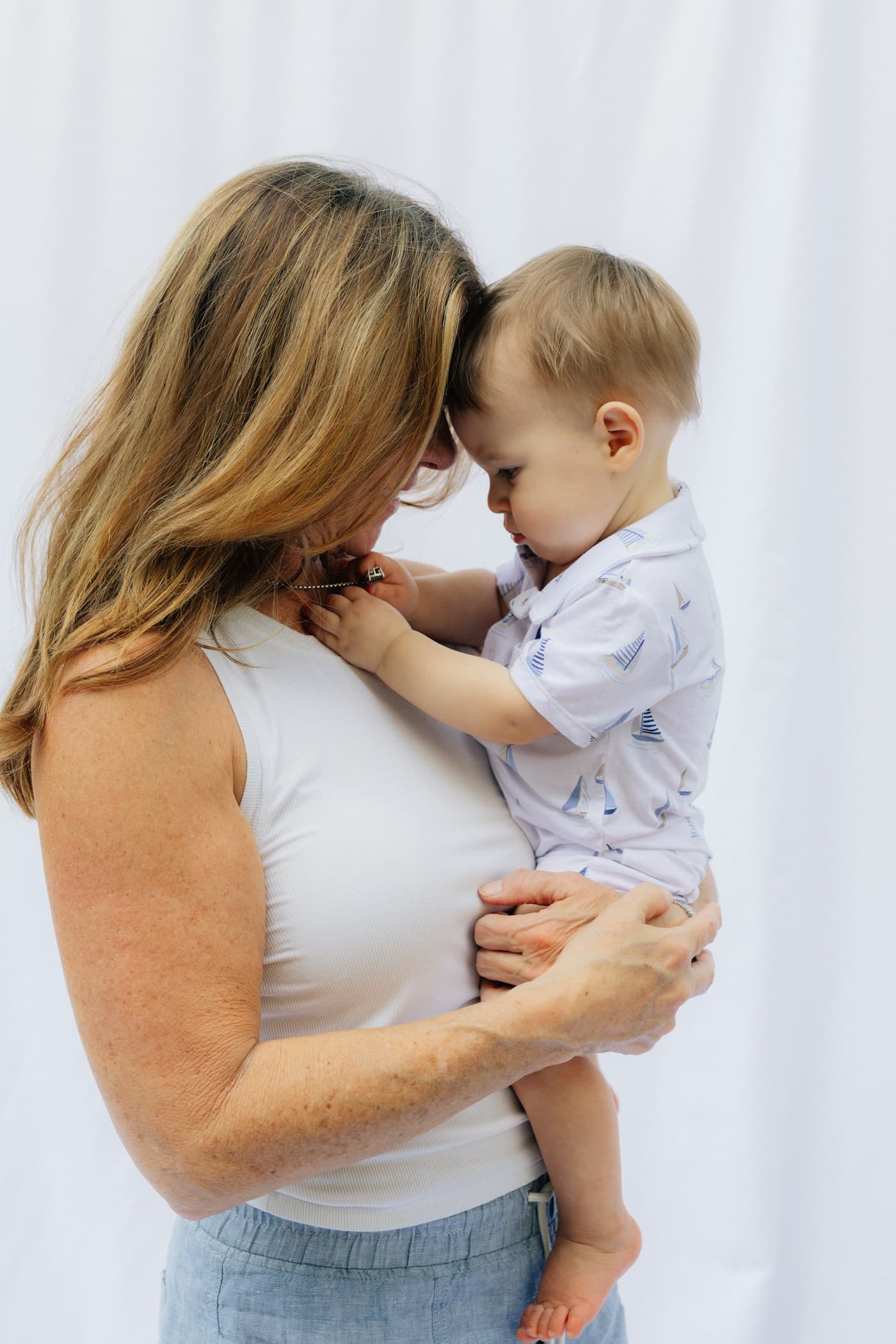 A foster carer holding a toddler close, their foreheads almost touching
